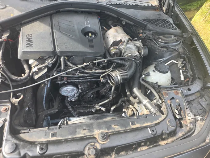 BMW engine bay mid-repair before a full service